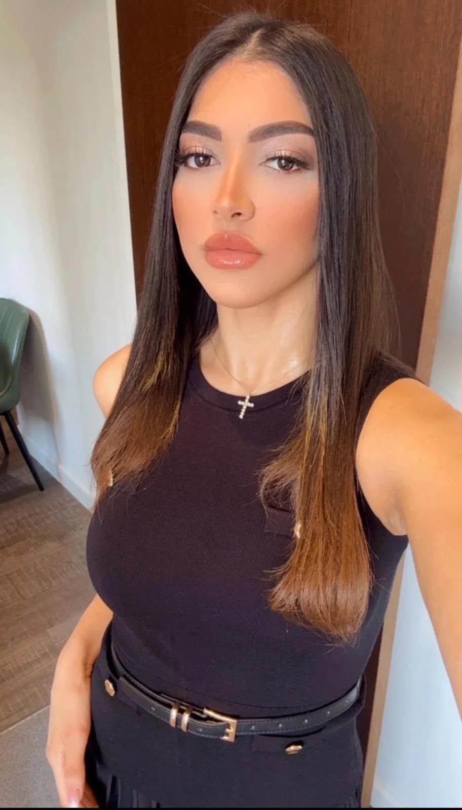 Woman with long dark hair wearing a black sleeveless top.