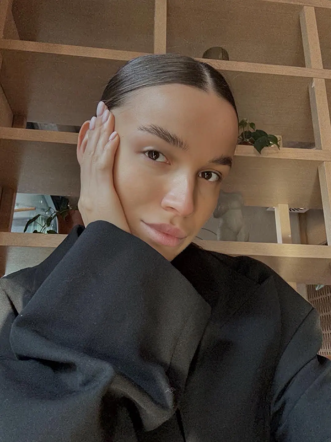 A woman with sleek hair wearing a black blazer.