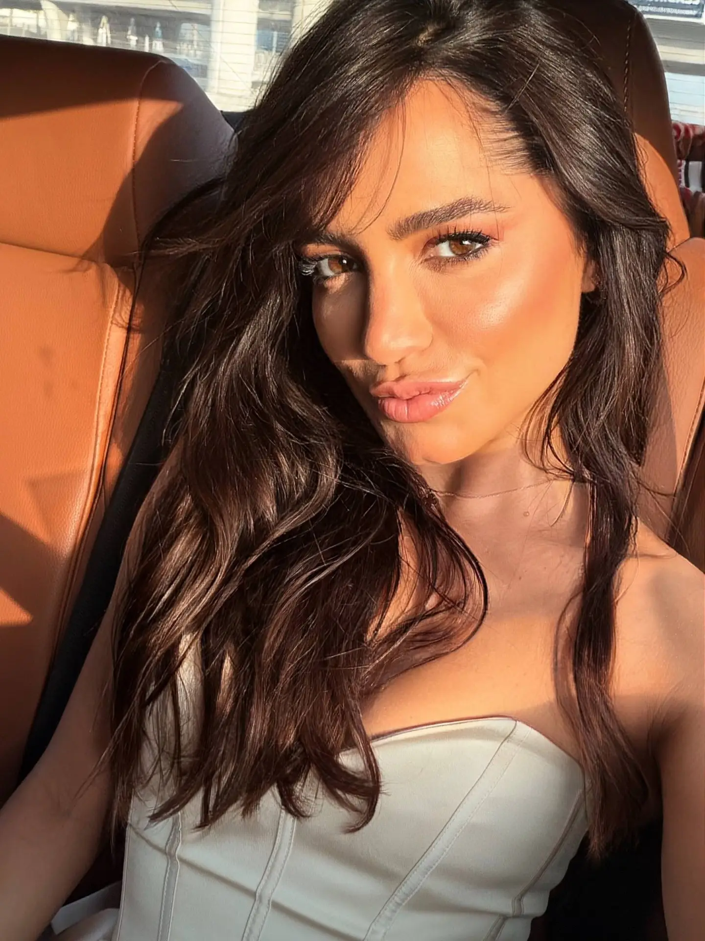 Sunlit close-up of a woman with brown hair in car