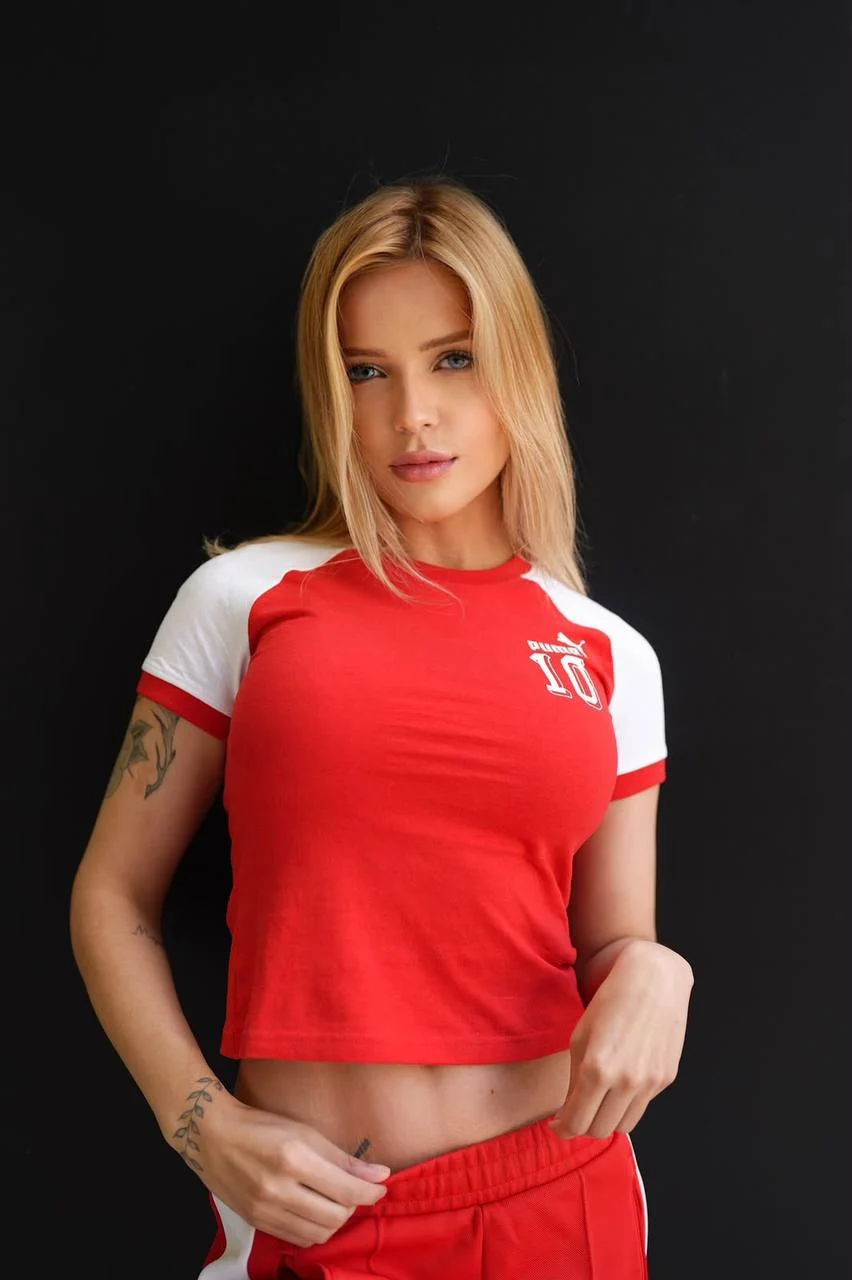 Blonde woman wearing red and white Puma sportswear.