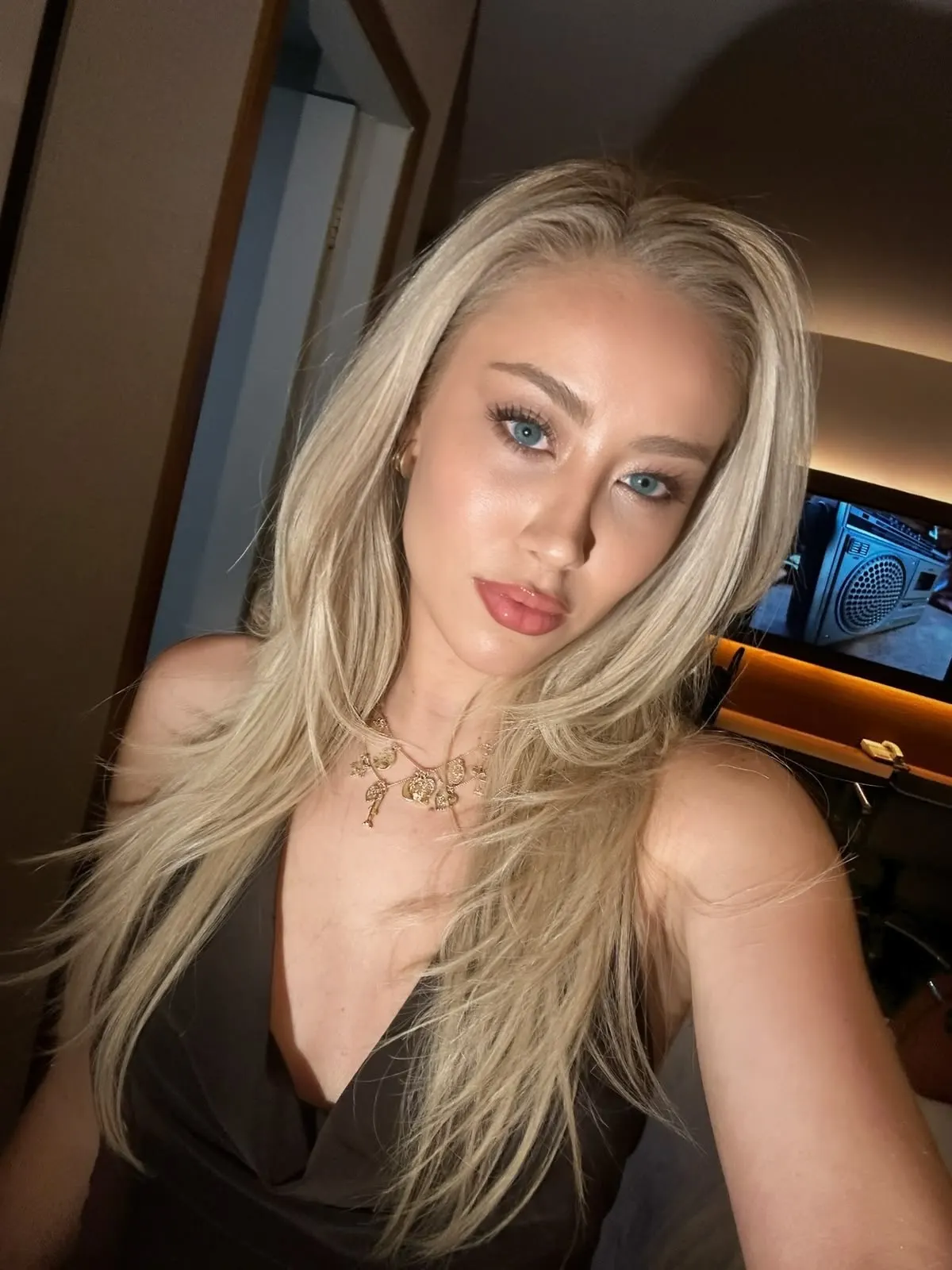 Portrait of a blonde woman with blue eyes and necklace.
