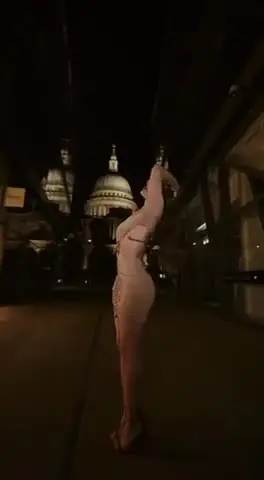 Woman posing at night near St. Pauls Cathedral.