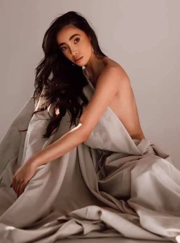Woman wrapped in beige fabric.