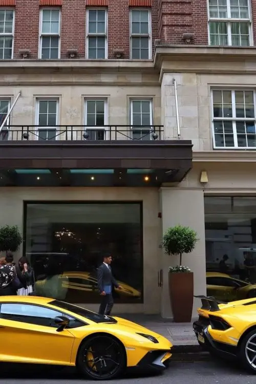 Two yellow sports cars outside a British hotel