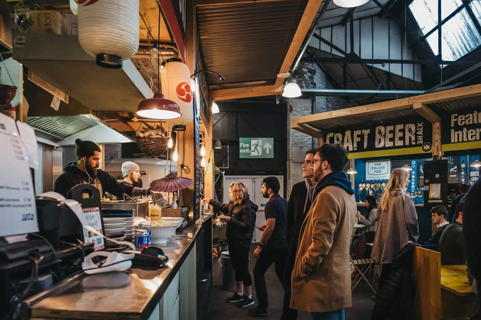 People ordering food at a market stall.