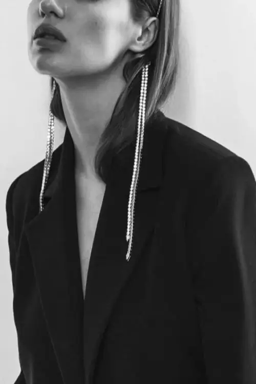 Aprilina, London escort in Paddington. Woman in black blazer with long earrings.