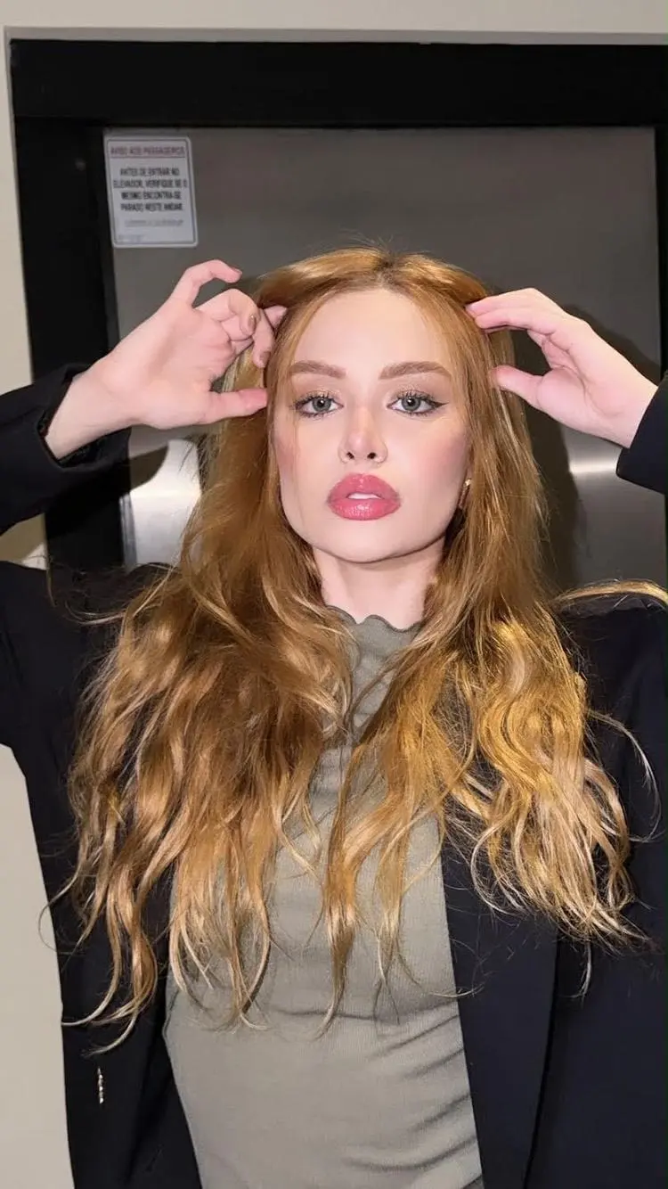 Portrait of a ginger-haired woman wearing a black blazer.