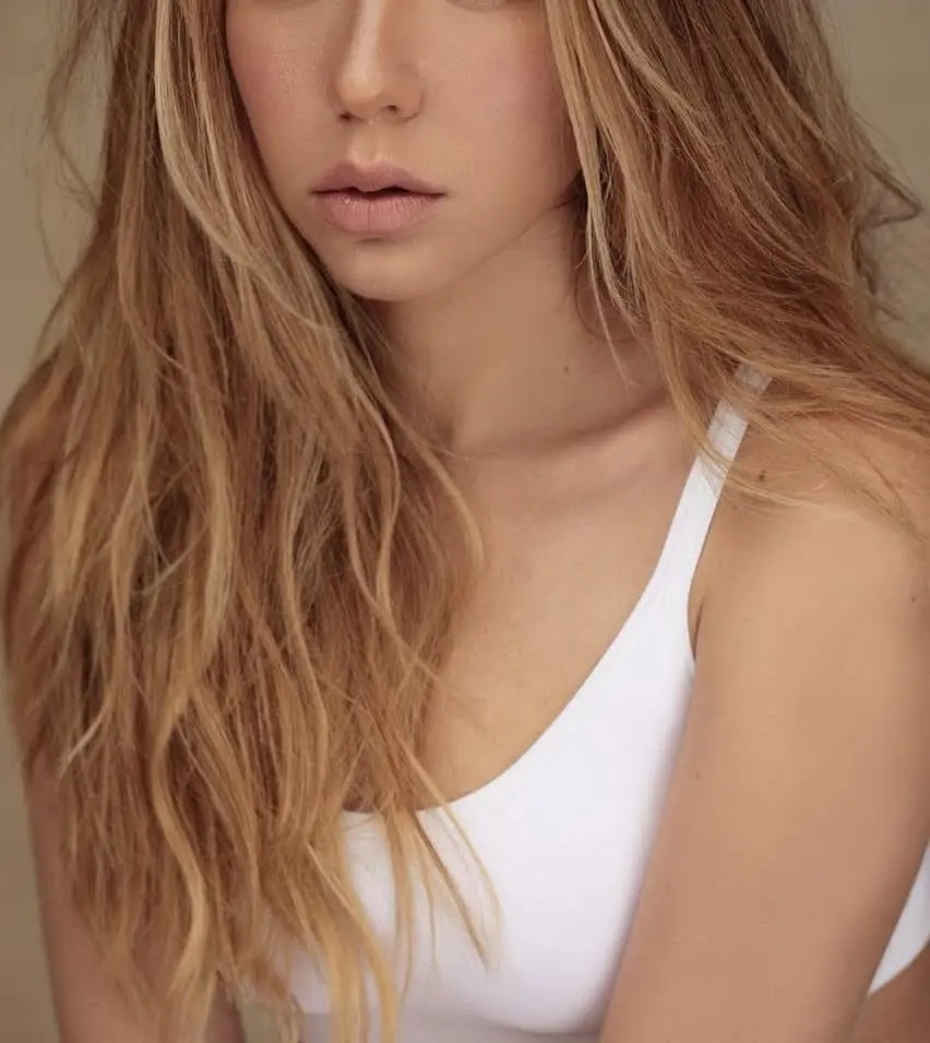 Close-up of a woman with long wavy blonde hair.