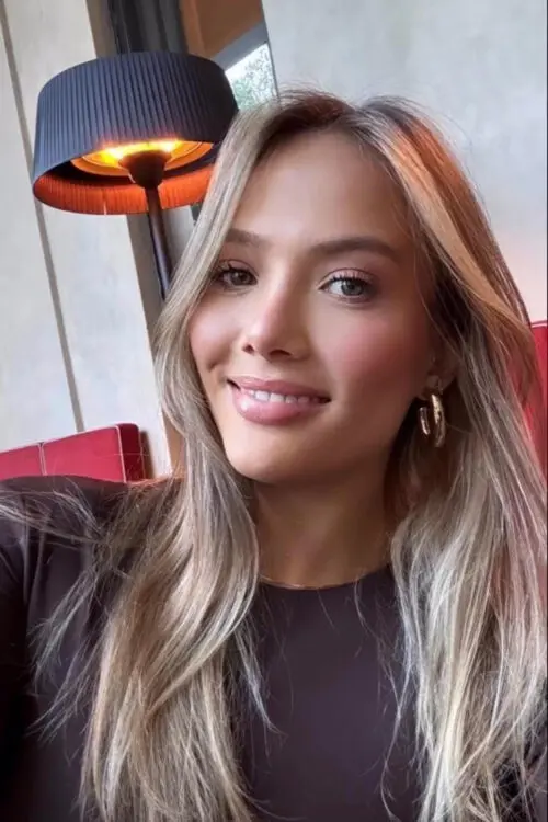 Close-up portrait of a smiling woman with blonde hair.