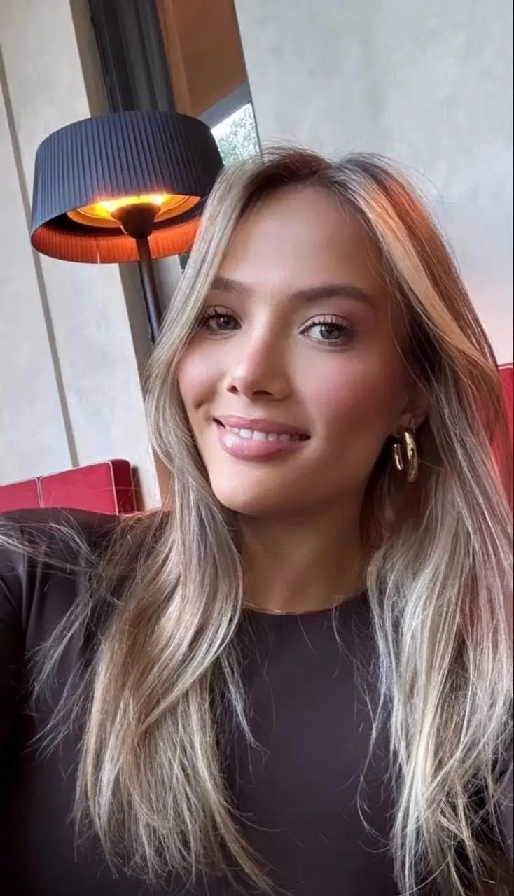Close-up portrait of a smiling woman with blonde hair.