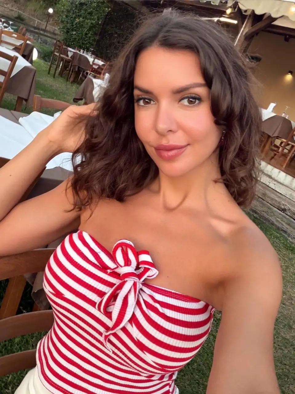 Smiling woman in a red and white striped tube top.