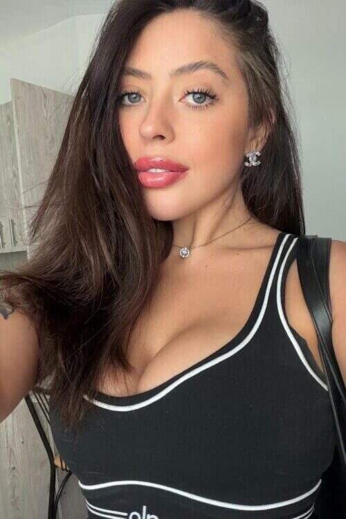 Woman with long brown hair wearing a black tank top