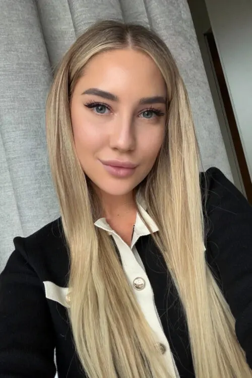 Blonde woman wearing a black and white cardigan