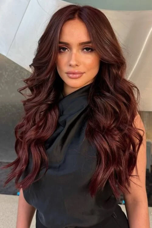 Woman with long, voluminous, wavy mahogany-coloured hair.