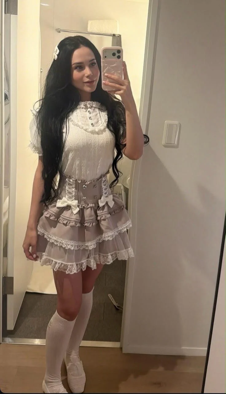 Woman taking a mirror selfie in a Lolita-style outfit