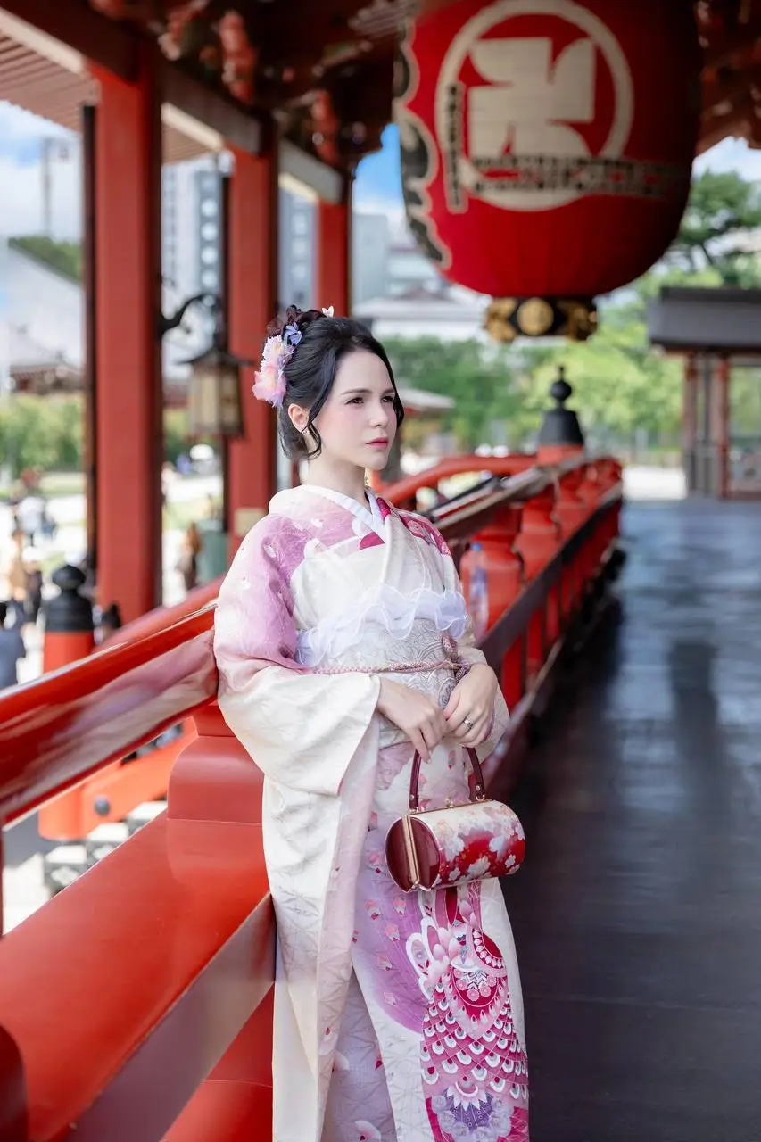 Woman in traditional kimono posing at a Japanese temple.