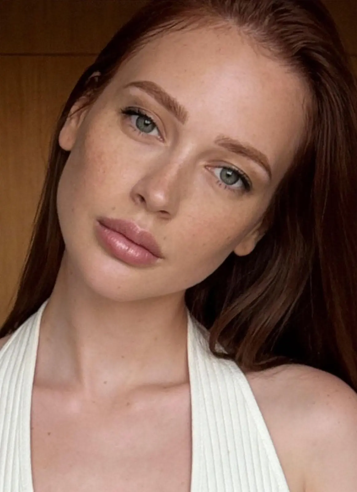 Portrait of a redhead woman with freckles and blue eyes.