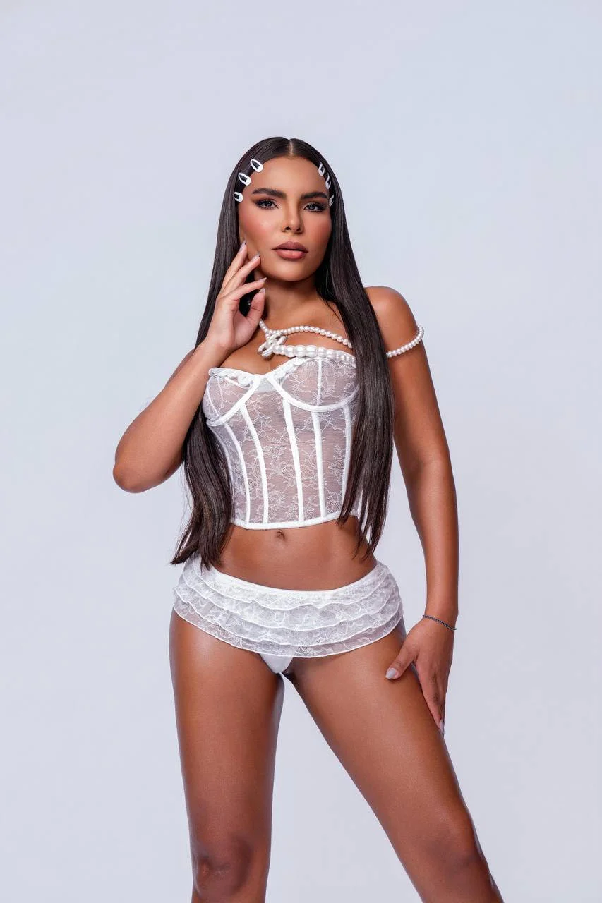 Woman posing in white lace corset and ruffled knickers