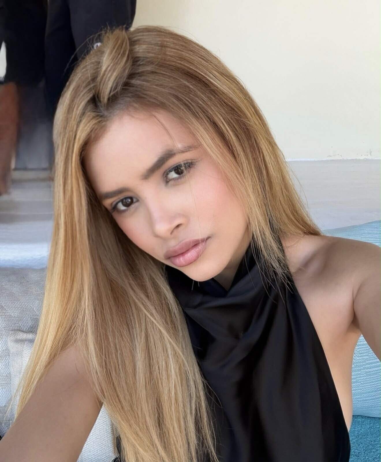 Portrait of a blonde woman in a black halter top.