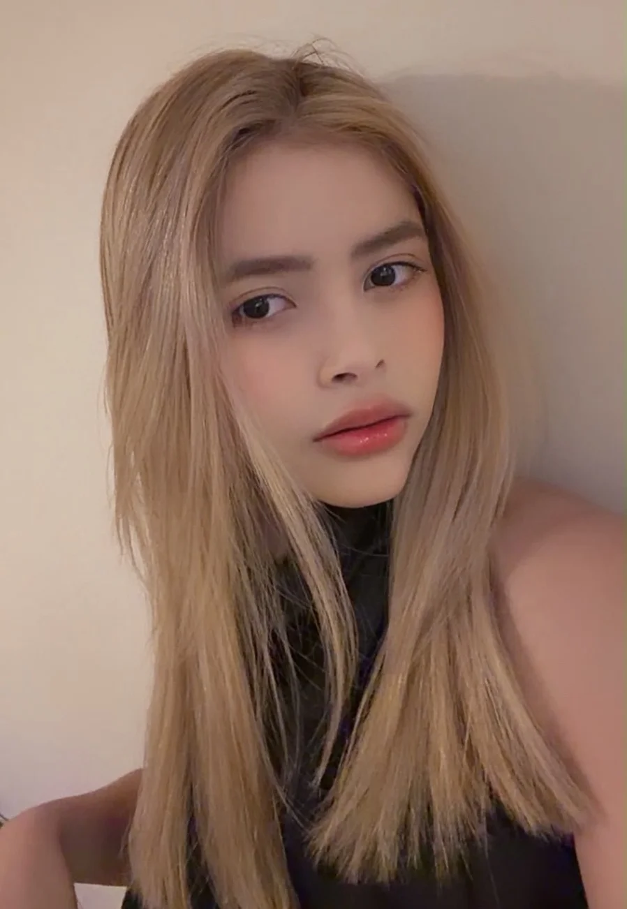 A young woman with long blonde hair and dark eyes.
