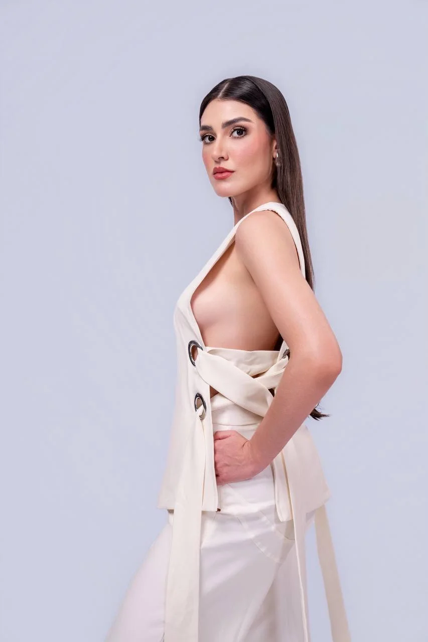 Woman posing in a white sleeveless top with open sides