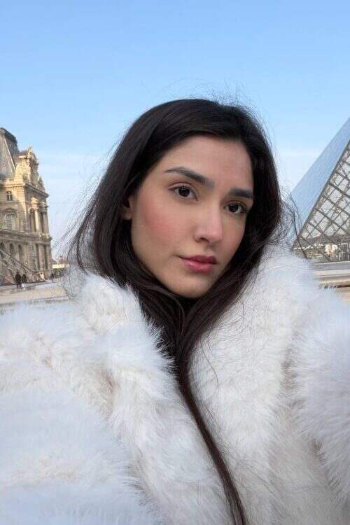 Selfie of a woman in white fur at the Louvre.