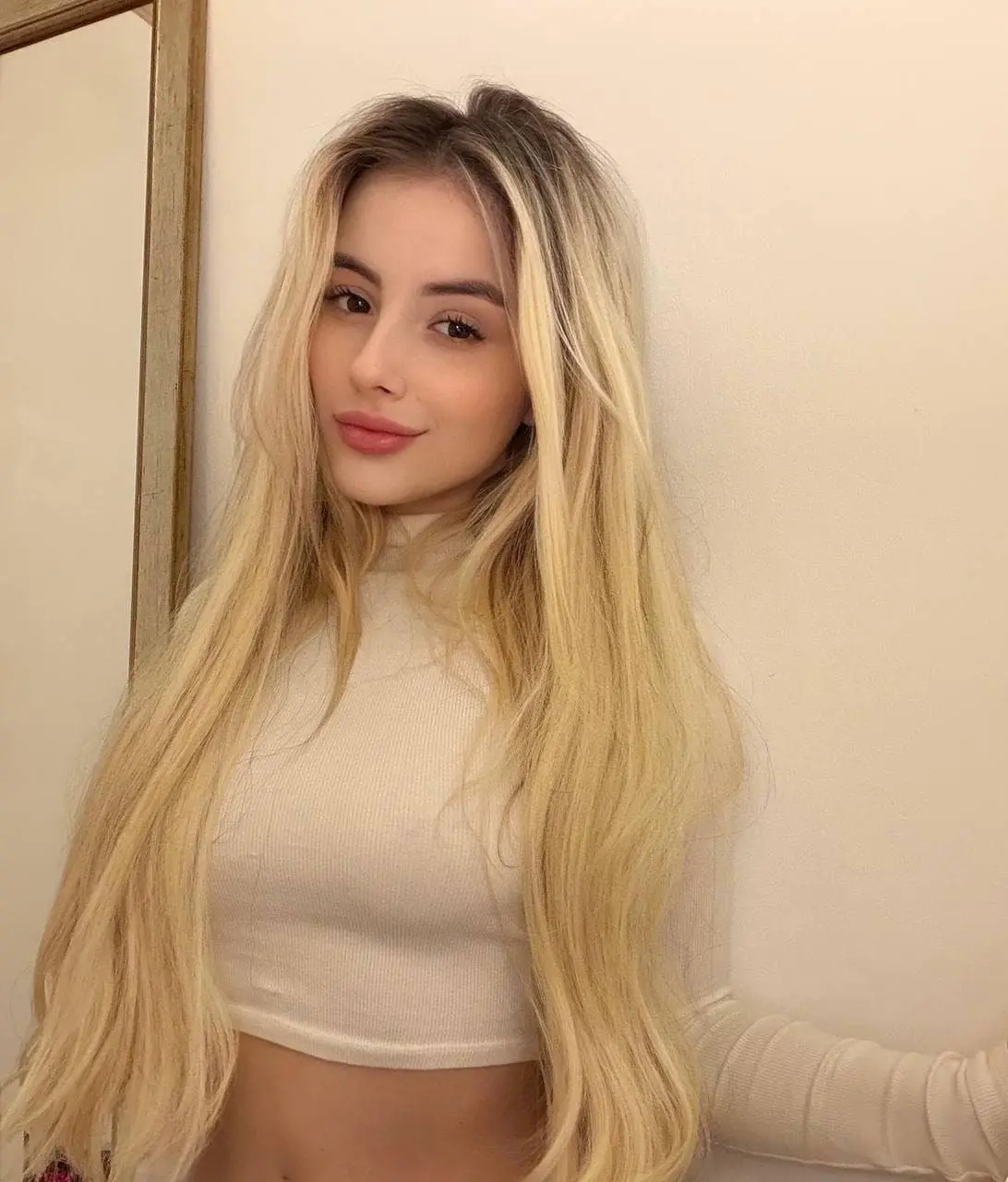 Portrait of a blonde woman in a cream crop top.