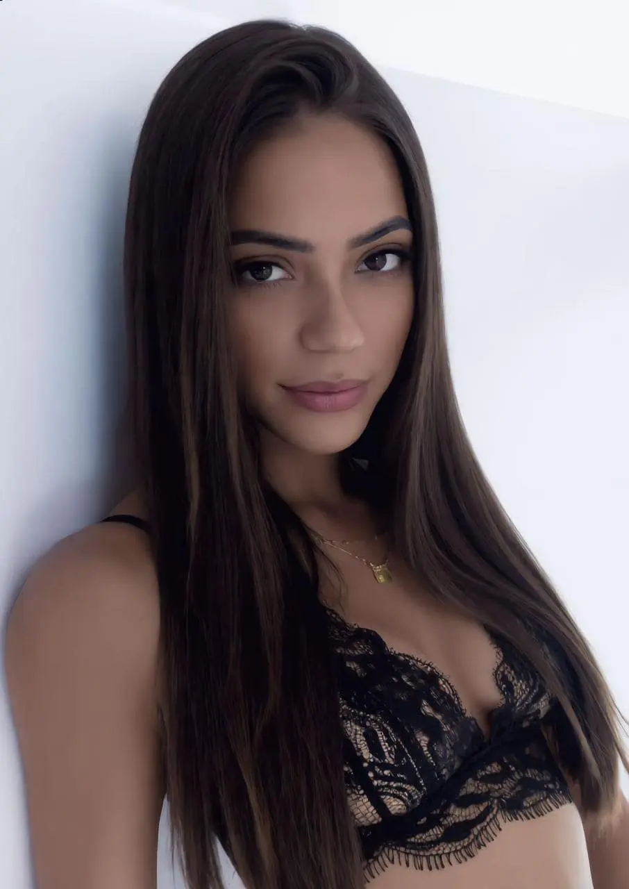 Woman with long dark brown hair in black lace lingerie.