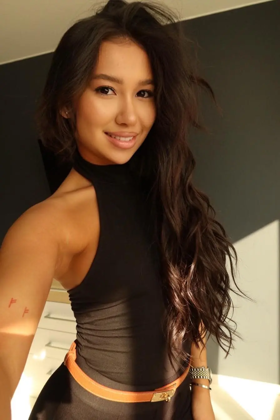 Smiling woman with long wavy hair in a black top.