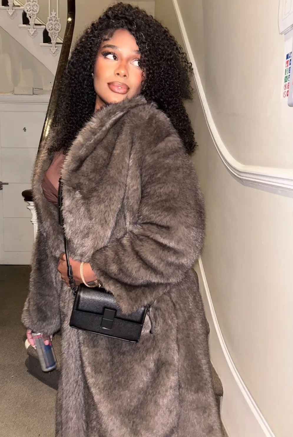 Woman in a brown faux fur coat and crossbody bag