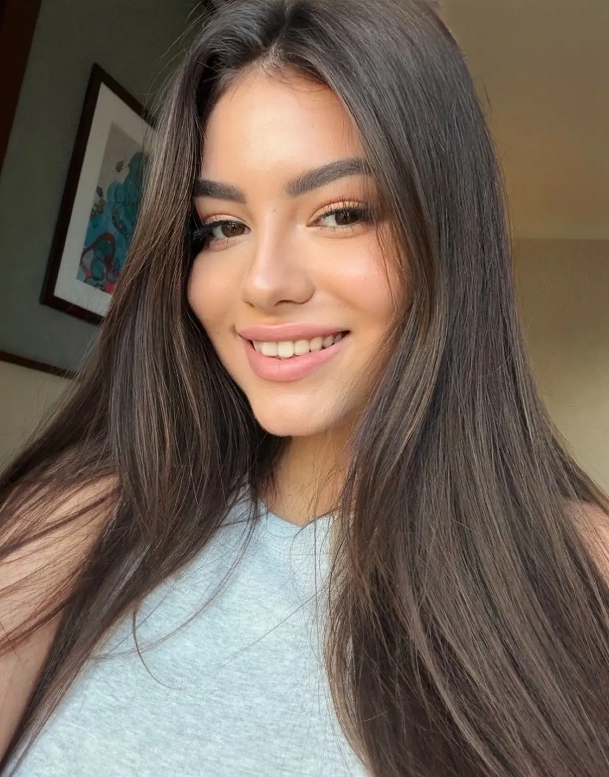 Smiling young woman with long dark brown hair.