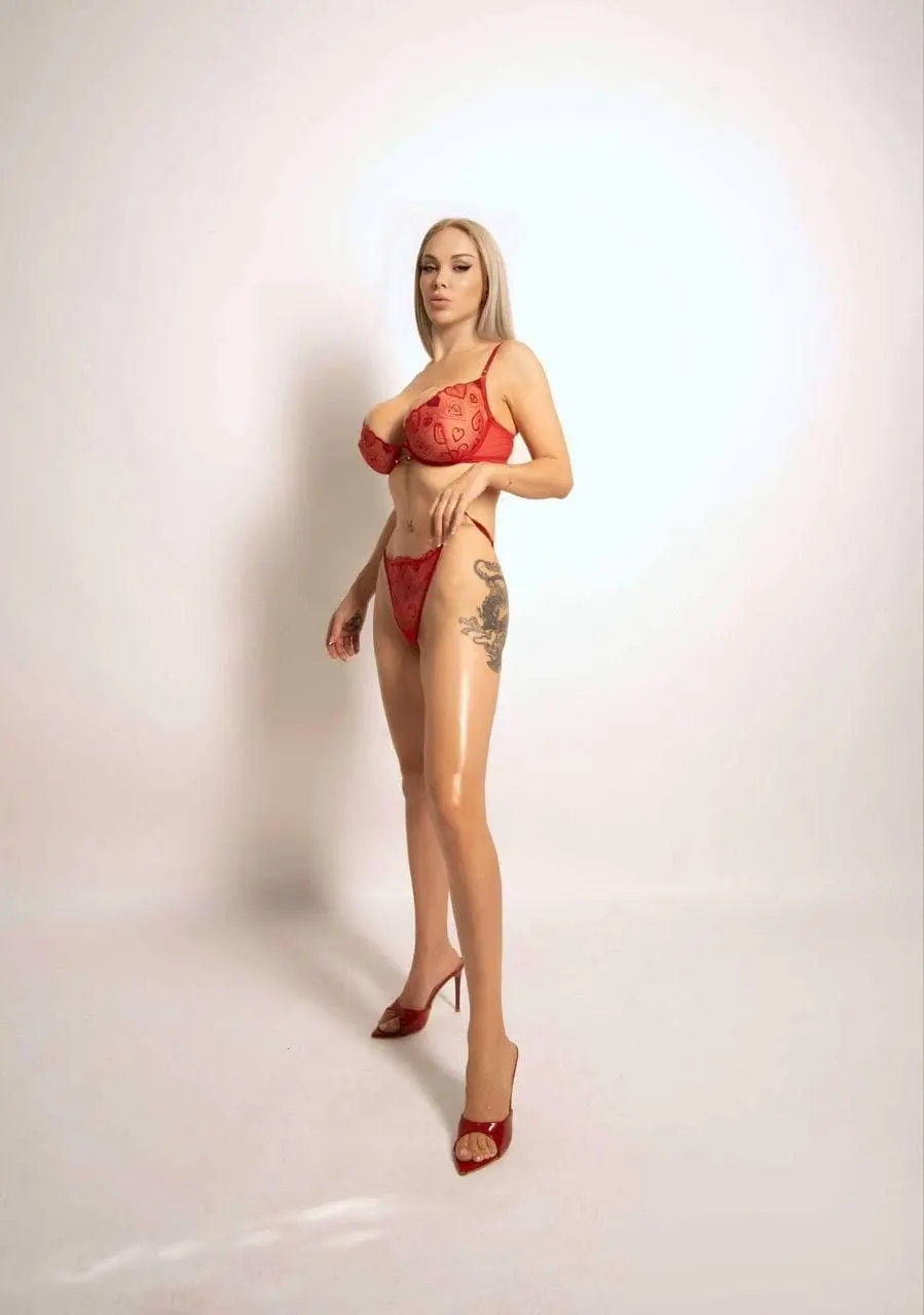 Blonde woman in red heart-patterned lingerie and red heels.