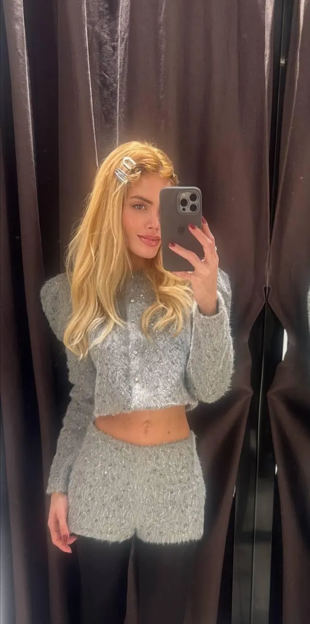 Blonde woman wearing grey fuzzy cardigan and matching shorts.