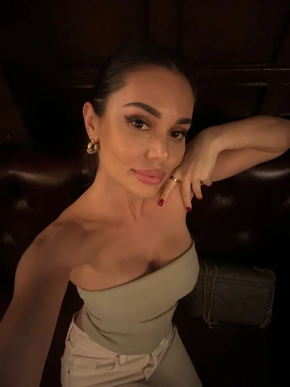 High-angle selfie of a woman in a sage green strapless top.