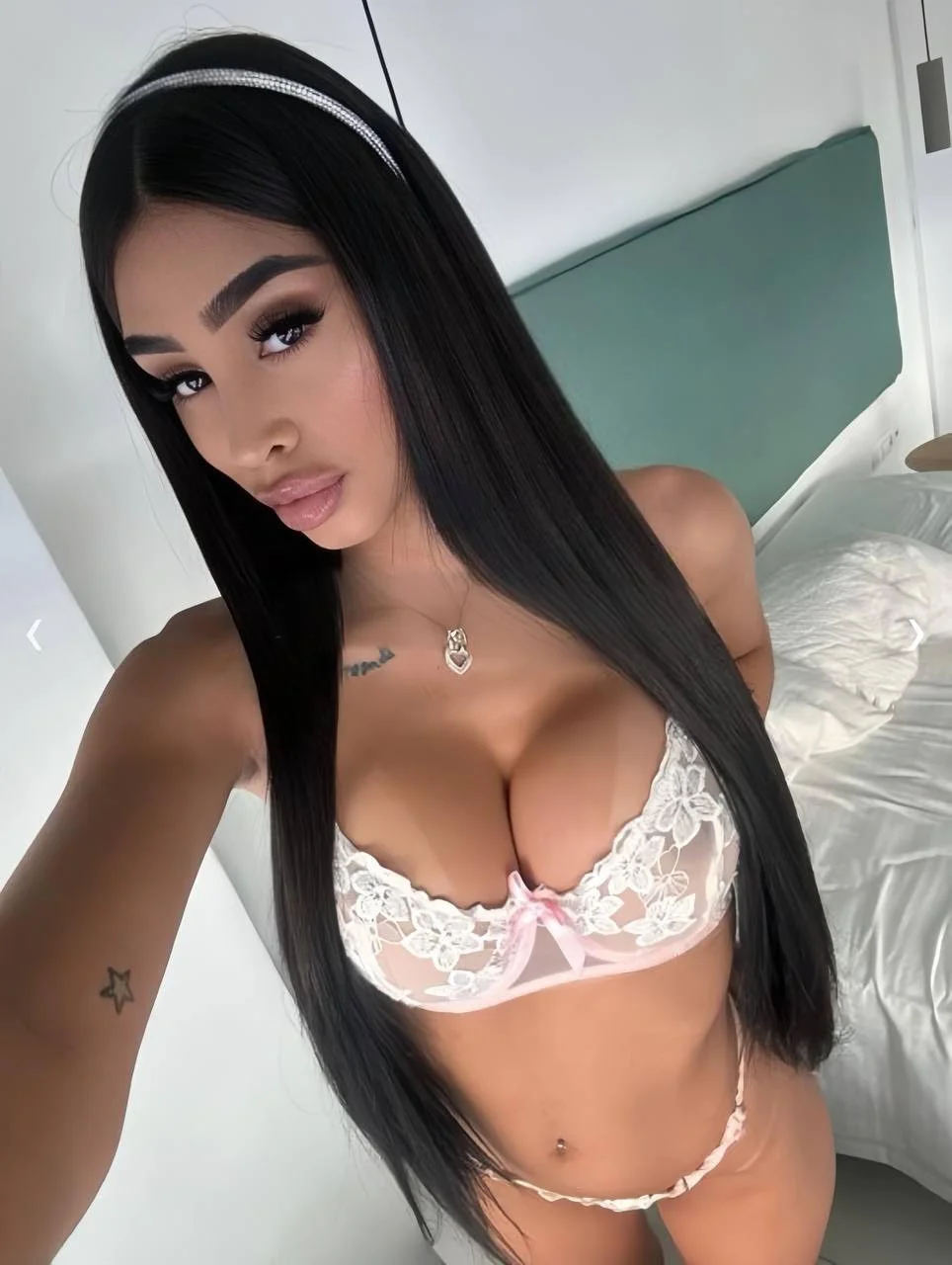 Woman with long black hair wearing white lace lingerie.