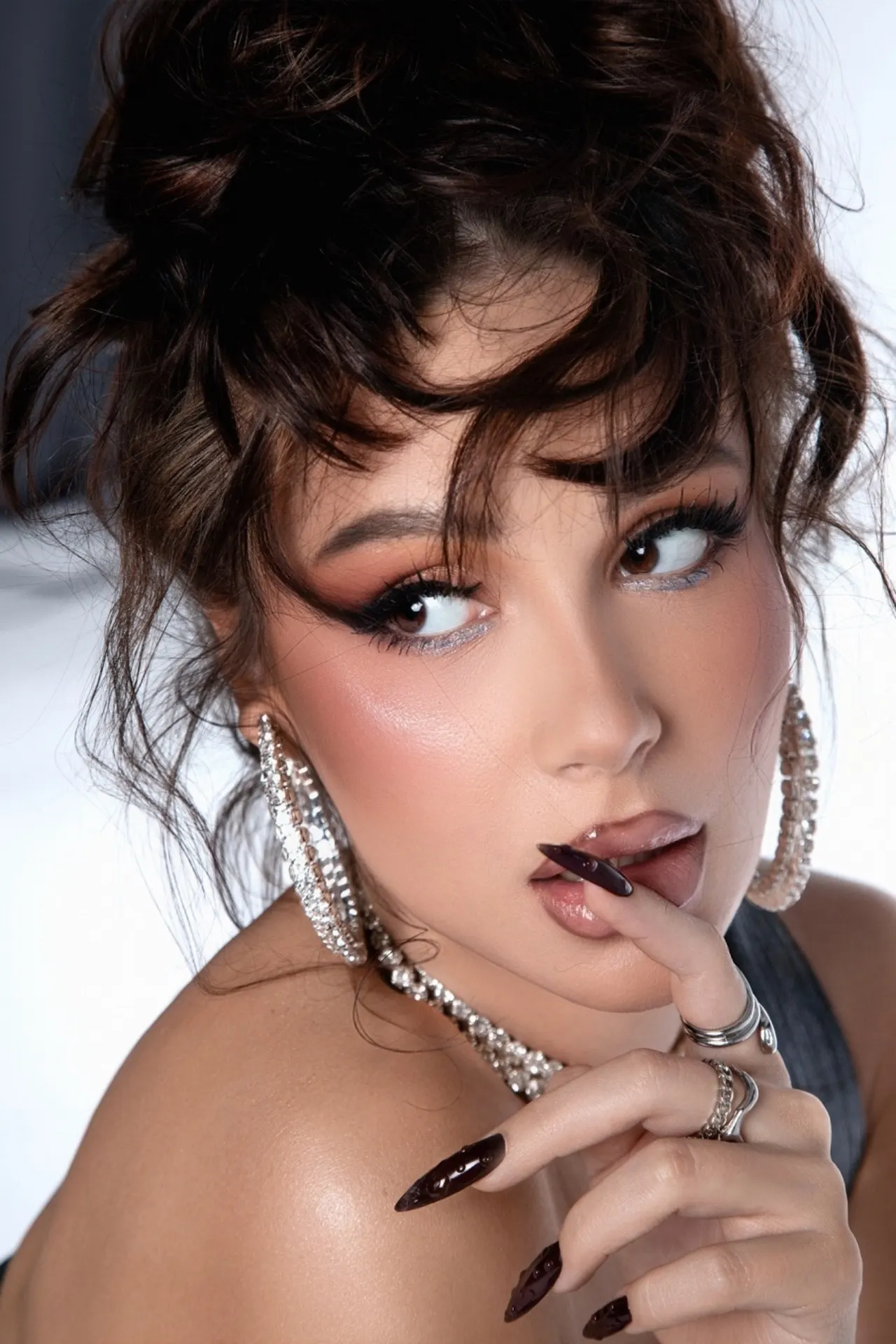 Glamour portrait of woman with dramatic makeup and sparkling jewellery.