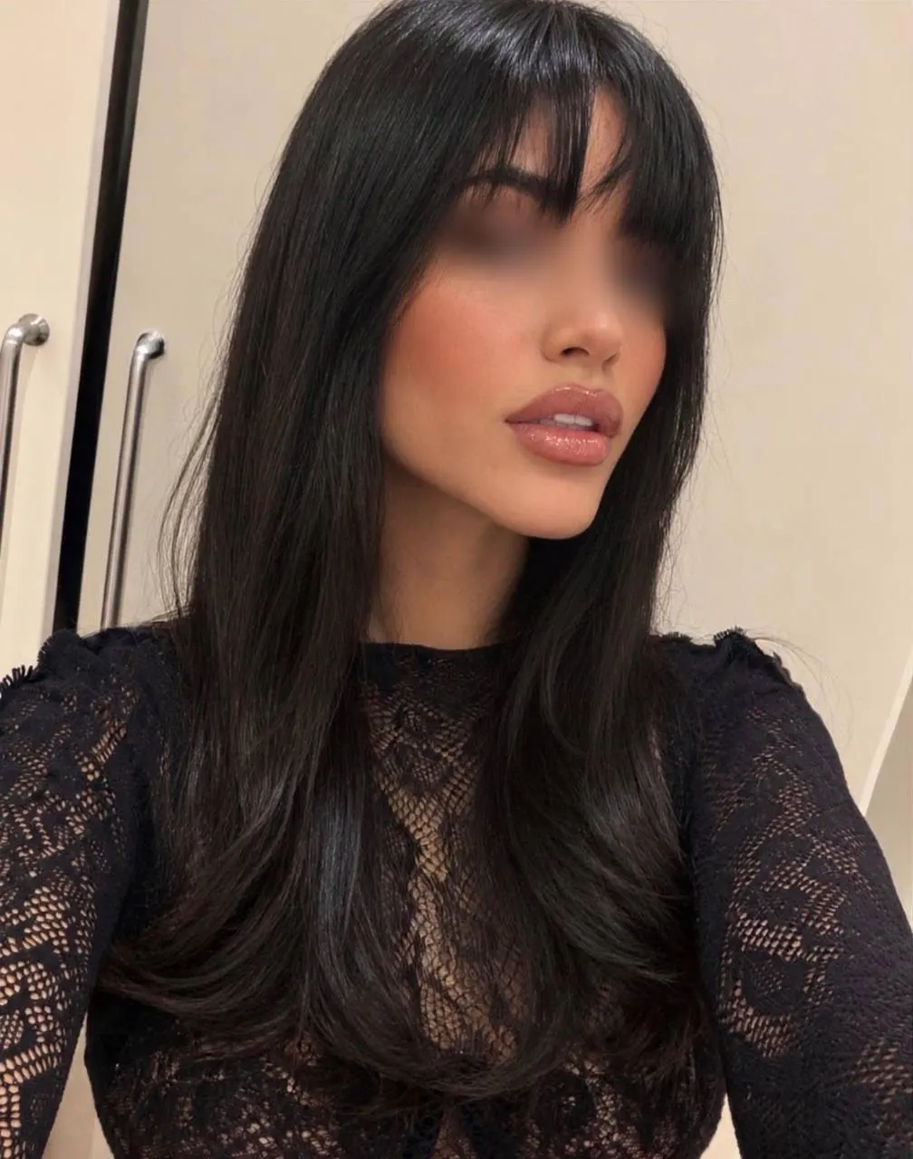 Woman with long black hair, fringe and black lace top