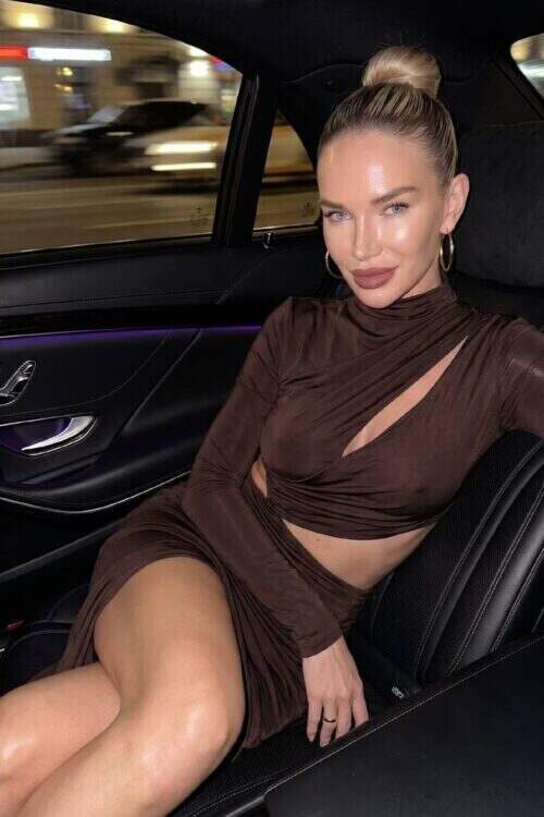 Woman in brown cut-out dress sitting in luxury car
